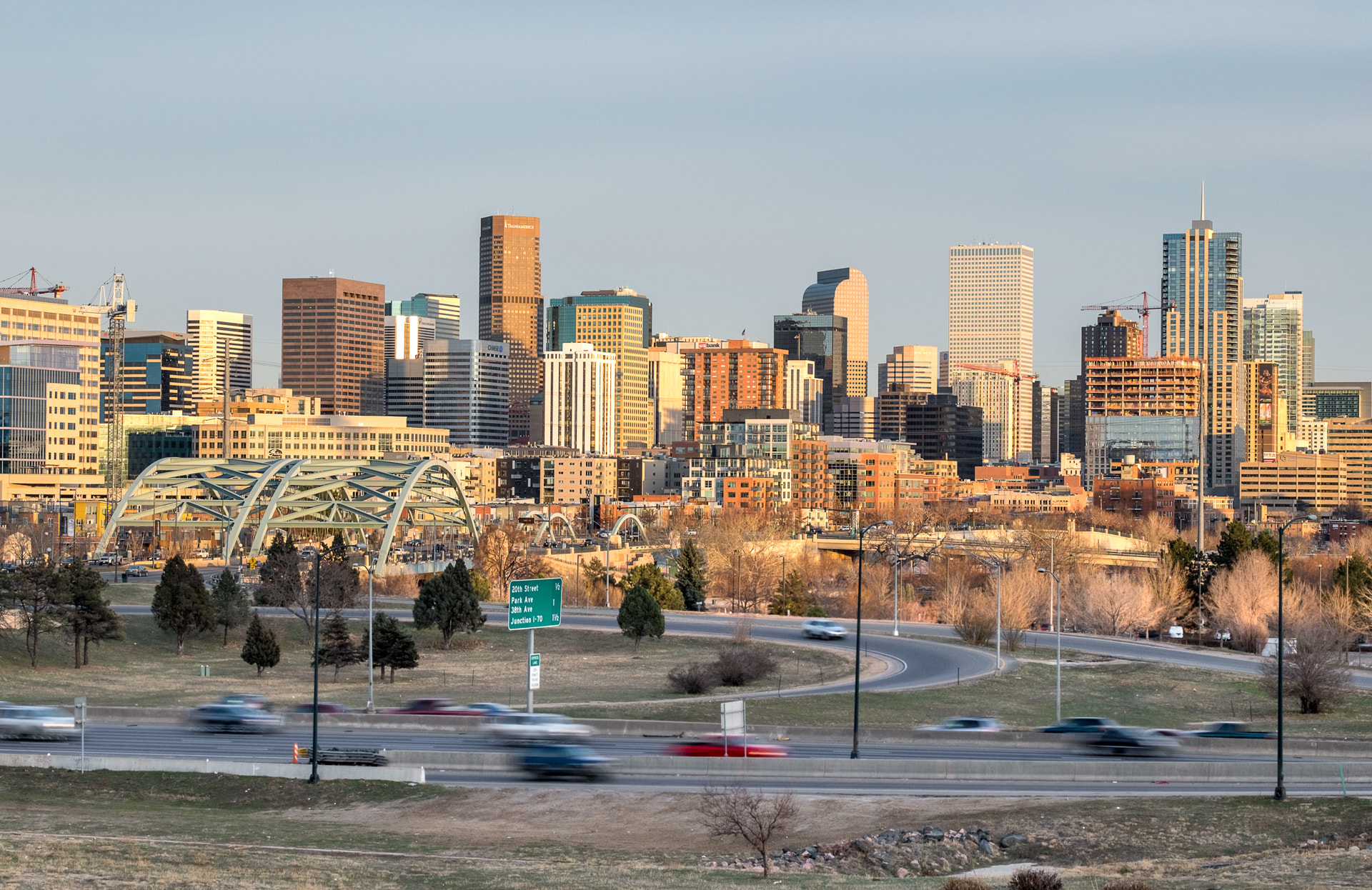 The Denver skyline at sunset, with city streets in the foreground.